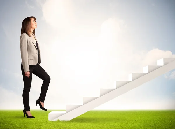 Business person climbing up on white staircase in nature Stock Photo