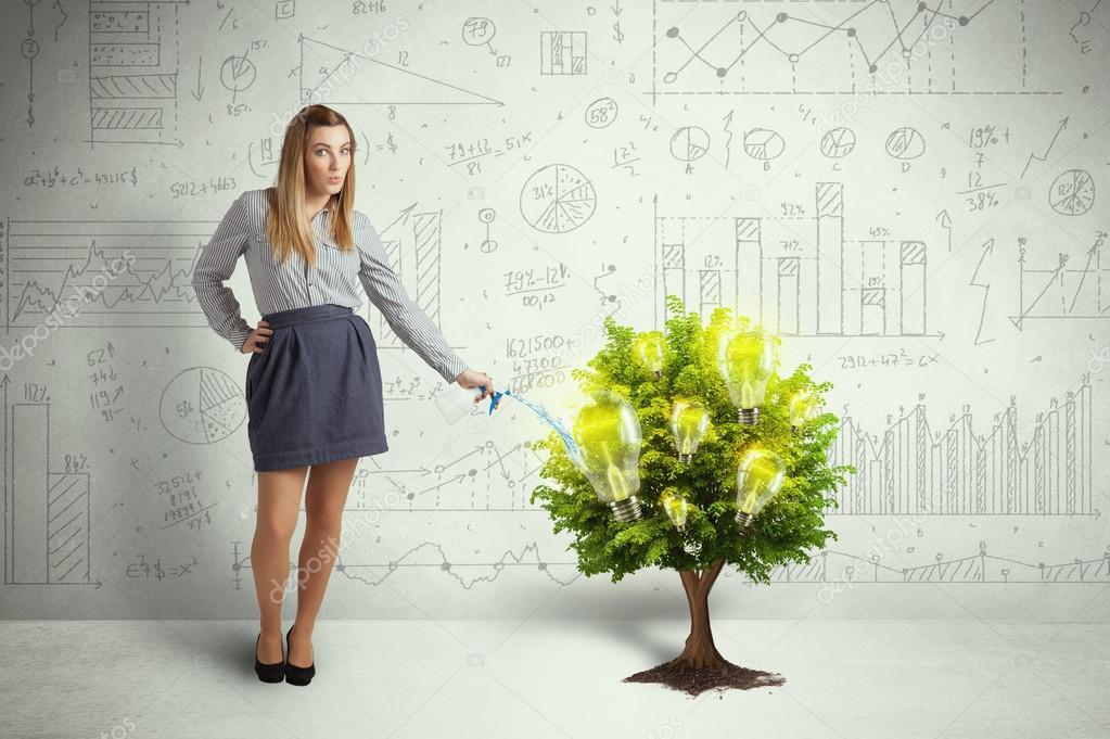 Business woman pouring water on lightbulb growing tree