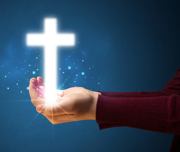 Glowing cross in the hand of a woman — Stock Photo, Image