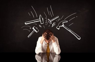 Depresyondaki işadamı çekiç izlerinin altında oturuyor