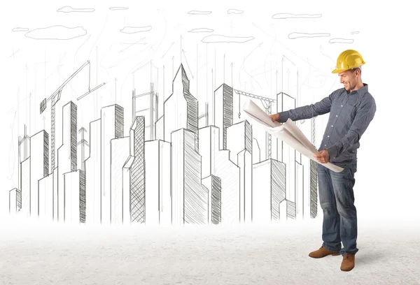Ingeniero hombre con el dibujo de la ciudad edificio en el fondo — Foto de Stock