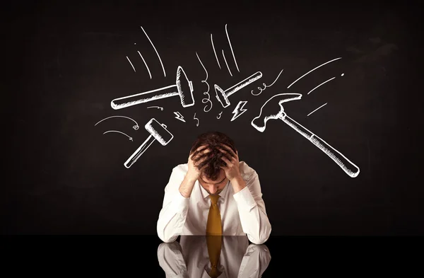 Depressiver Geschäftsmann sitzt unter Hammer — Stockfoto