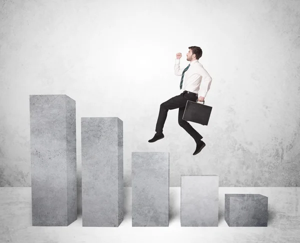 Successful business man jumping over charts on background — Stock Photo, Image