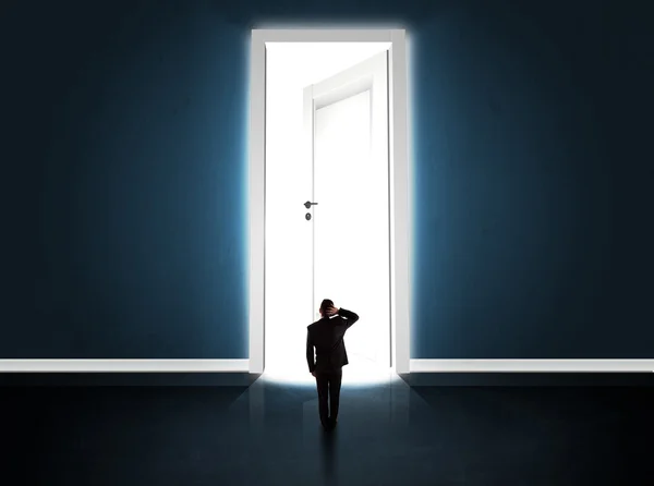 Geschäftsmann blickt auf große helle geöffnete Tür — Stockfoto
