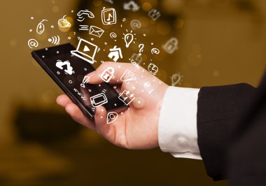 Medya simgeleri ve sembolleriyle el ele tutuşan akıllı telefon 