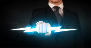 İşadamı elinde parlayan bir şimşek tutuyor.