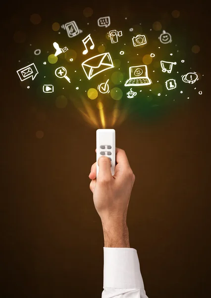 Hand with remote control and social media icons — Stock Photo, Image