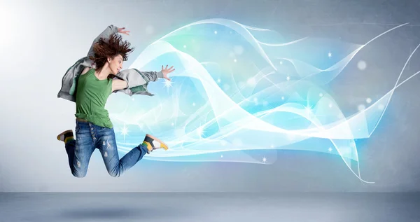 Cute teenager jumping with abstract blue scarf around her — Stock Photo, Image