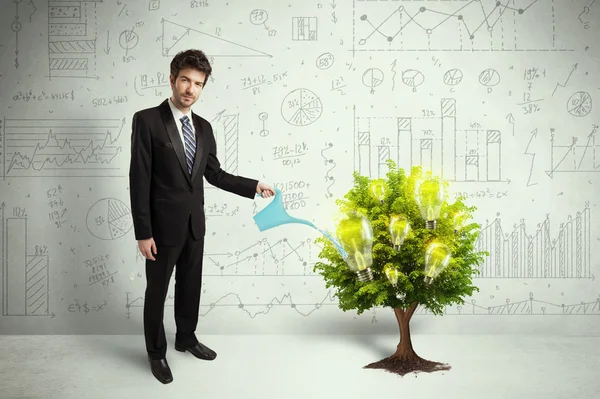 Business man pouring water on lightbulb growing tree — Stock Photo, Image