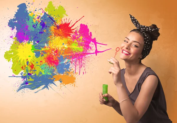 Cute girl blowing colorful splash graffiti — Stock Photo, Image