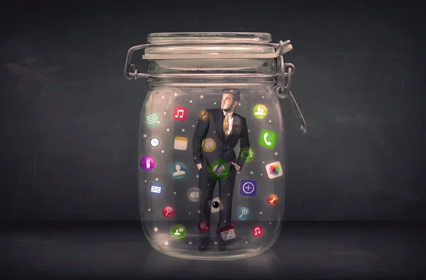 Businessman captured in a glass jar with colourful app icons con — Stock Photo, Image