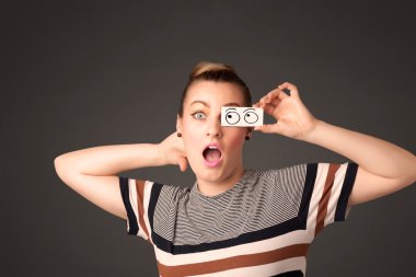 Elle çizilmiş göz küreleriyle kağıda bakan genç aptal kız.