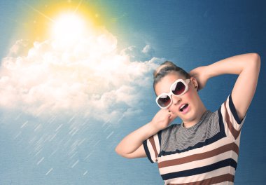 Güneş gözlükleriyle bulutlara ve güneşe bakan genç adam