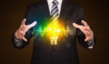 Elinde ampul tutan bir iş adamı.