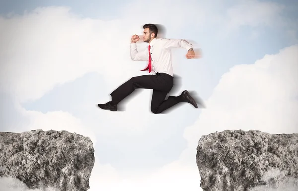 Смішний бізнесмен стрибає по каменях з прогалиною — стокове фото