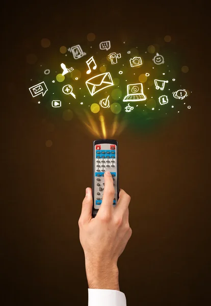 Hand with remote control and social media icons — Stock Photo, Image