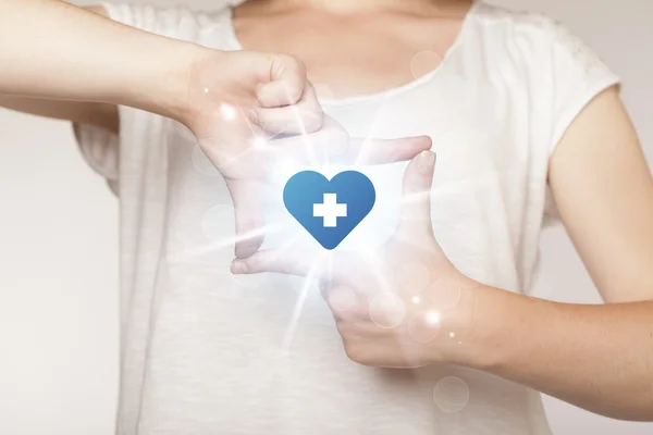 Ruce vytváří formulář s modrým srdcem kříž — Stock fotografie