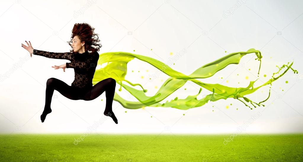 Pretty girl jumping with green abstract liquid dress
