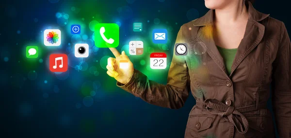 Joven empresaria presionando iconos de aplicaciones móviles de colores con boke — Foto de Stock