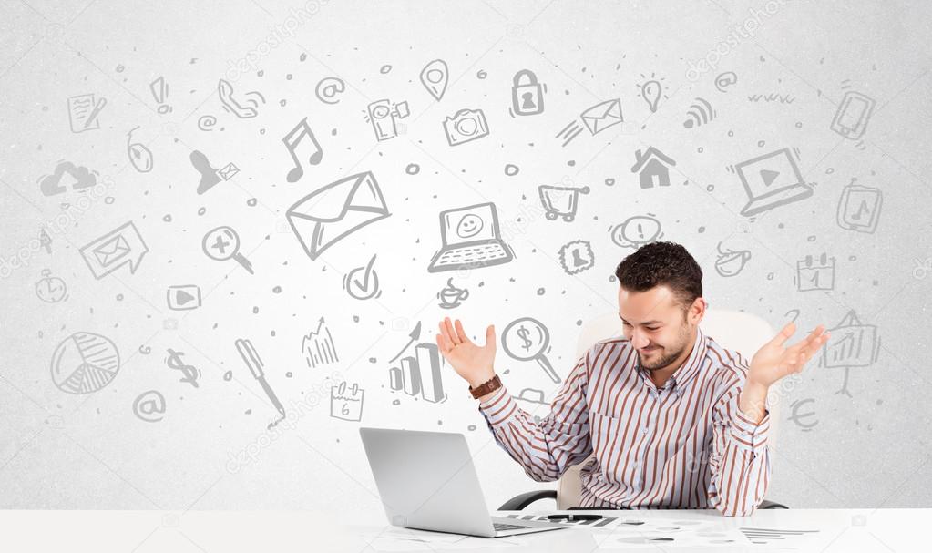 Business man  sitting at table with hand drawn media icons