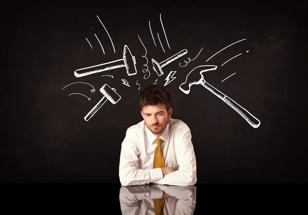 Depressiver Geschäftsmann sitzt unter Hammer — Stockfoto