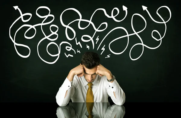 Depressed businessman sitting under drawn direction lines — Stock Photo, Image