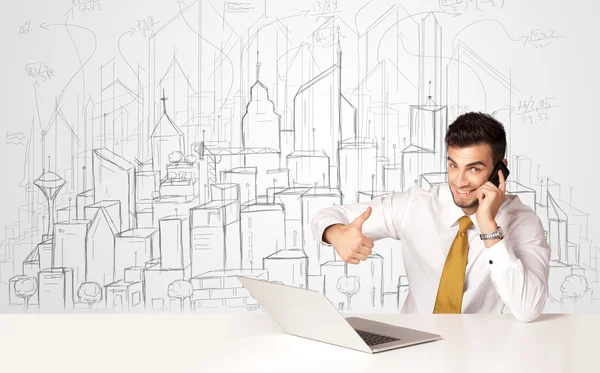 Zakenman zittend aan de witte tafel met handgetekende gebouwen — Stockfoto