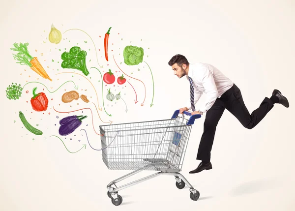 Empresário com carrinho de compras com legumes — Fotografia de Stock