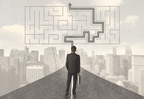 Бизнесмен смотрит на дорогу с лабиринтом и решением