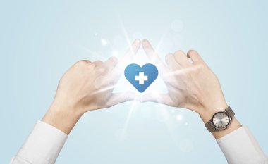 Eller mavi haçlı bir kalp yaratıyor.