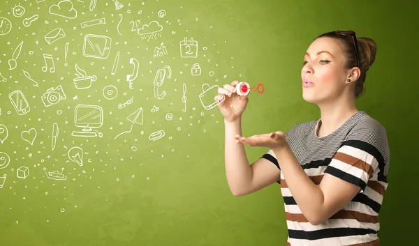 Cute girl blowing hand drawn media icons and symbols — Stock Photo, Image