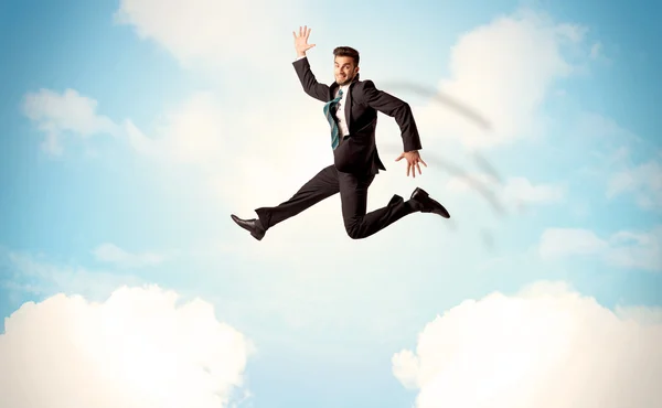 Biznesmen skaczący przez chmury na niebie — Zdjęcie stockowe