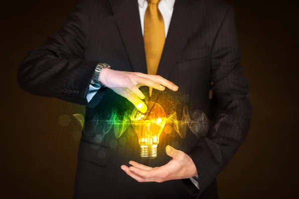 Businessman holding light bulb — Stock Photo, Image