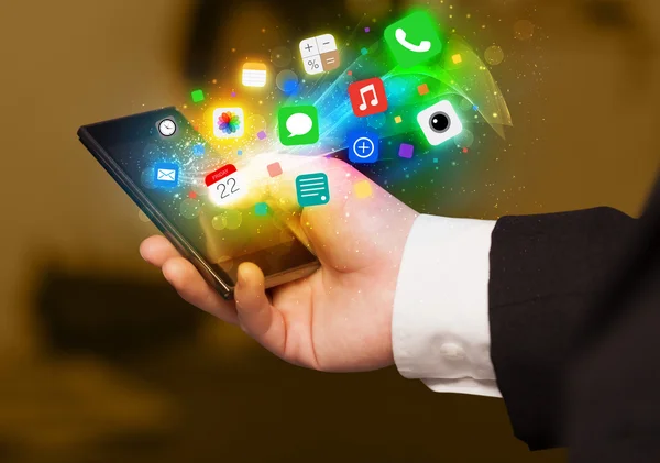 Hand innehav smartphone med färgglada app ikoner — Stockfoto