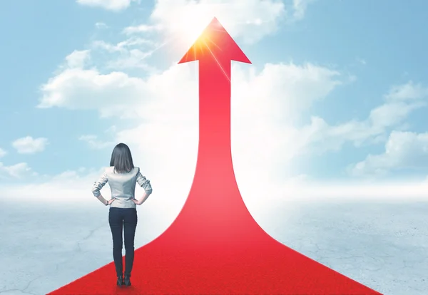 Businesswoman standing on a red arrow — Stock Photo, Image