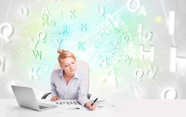 Business woman at desk with green word cloud — Stock Photo, Image