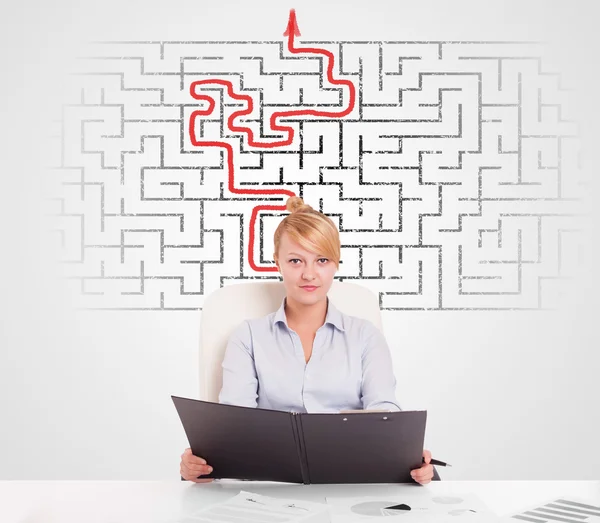 Business woman at desk with labyrinth and arrow — Stock Photo, Image