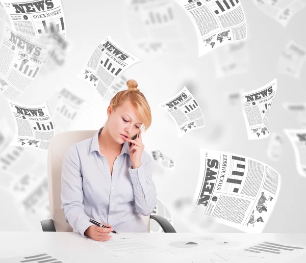 Business woman at desk with stock market newspapers — Stock Photo, Image