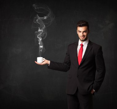Beyaz buharlı bir bardak tutan bir iş adamı.