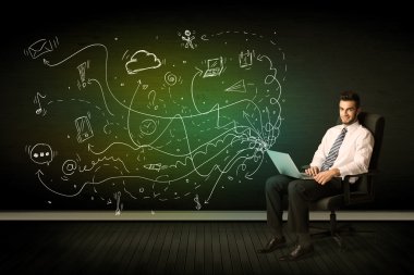 laptop medya simgeler ile tutarak sandalyede oturan işadamı