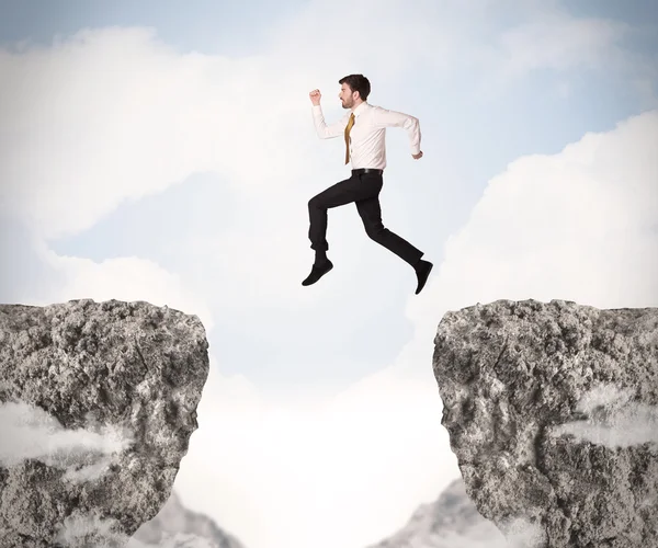 Funny business man jumping over rocks with gap — Stock Photo, Image