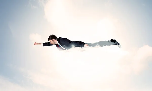 Geschäftsmann fliegt wie ein Superheld in Wolken am Himmel — Stockfoto