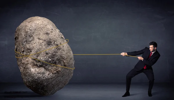 Geschäftsmann zieht riesigen Felsen mit Seil — Stockfoto