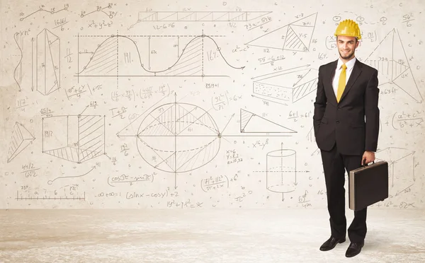 Handsome engineer calculating with hand drawn background — Stock Photo, Image