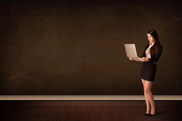 Businesswoman holding high tech laptop on background with copysp — Stock Photo, Image