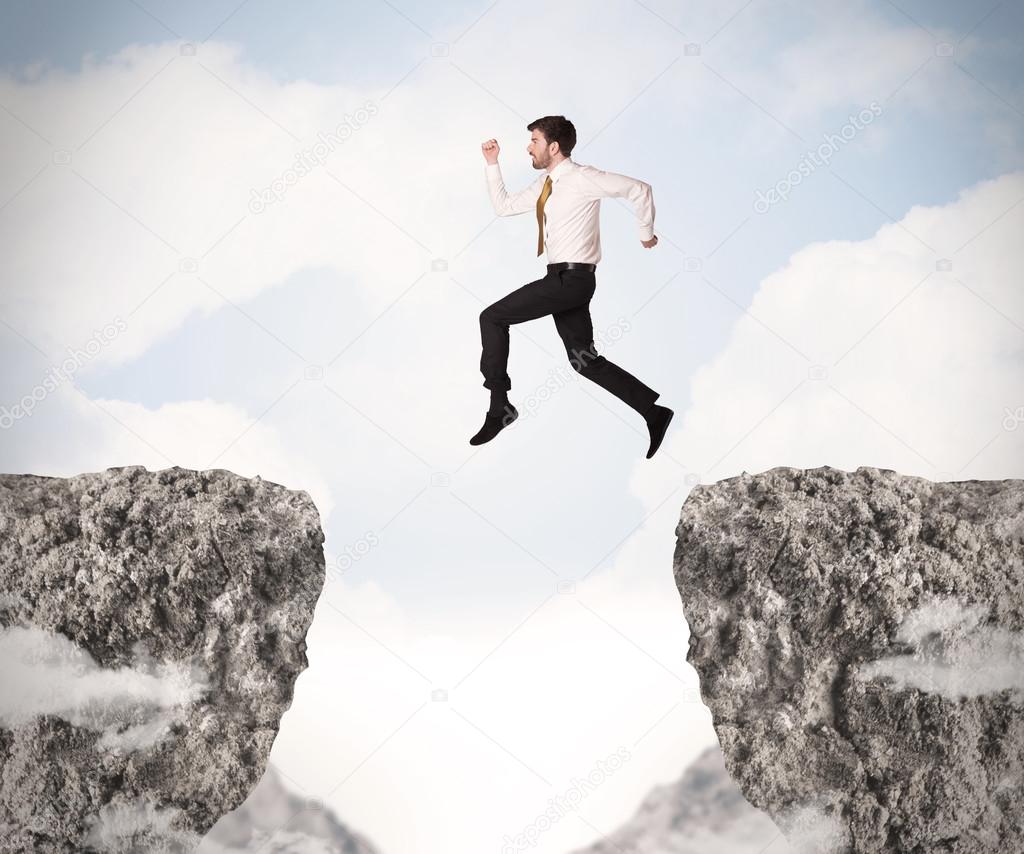 Funny business man jumping over rocks with gap