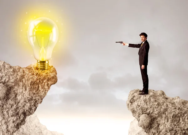 Businessman on rock mountain with idea bulb — Stock Photo, Image