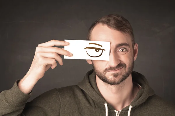 Young person holding paper with angry eye drawing — Stock Photo, Image