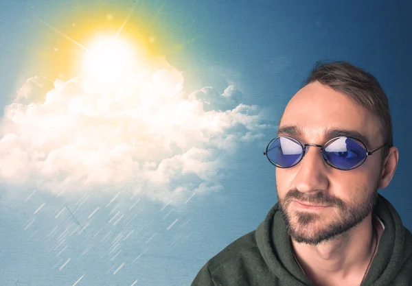 Young person looking with sunglasses at clouds and sun — Stock Photo, Image