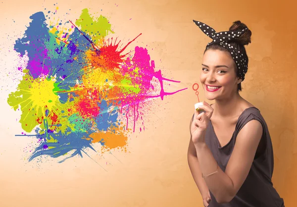 Cute girl blowing colorful splash graffiti — Stock Photo, Image